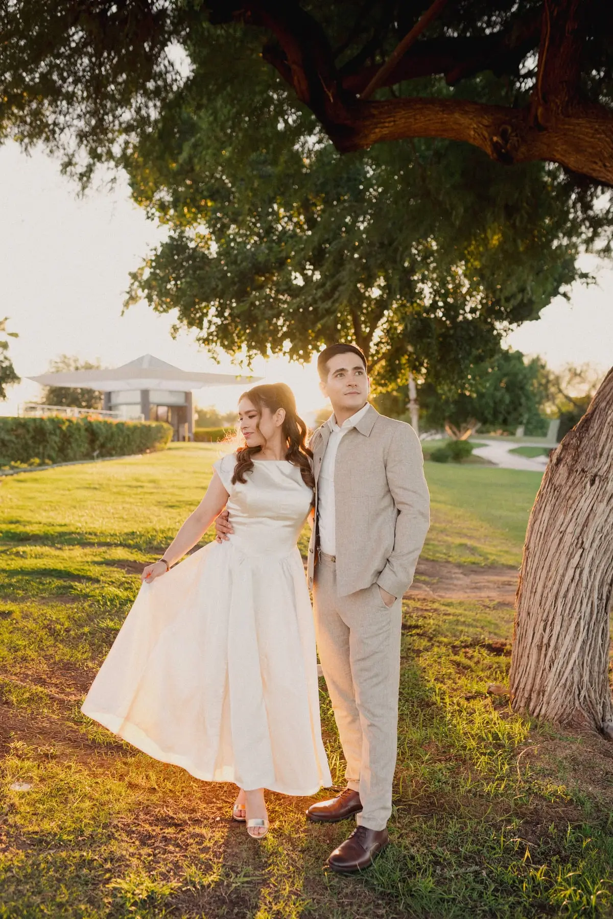 Pareja con vestido claro y traje de lino en un jardín